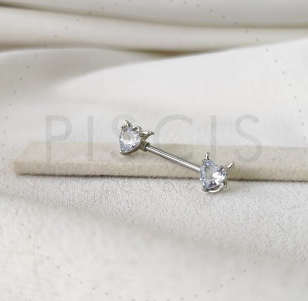 Piercing pezonera diablito blanco.